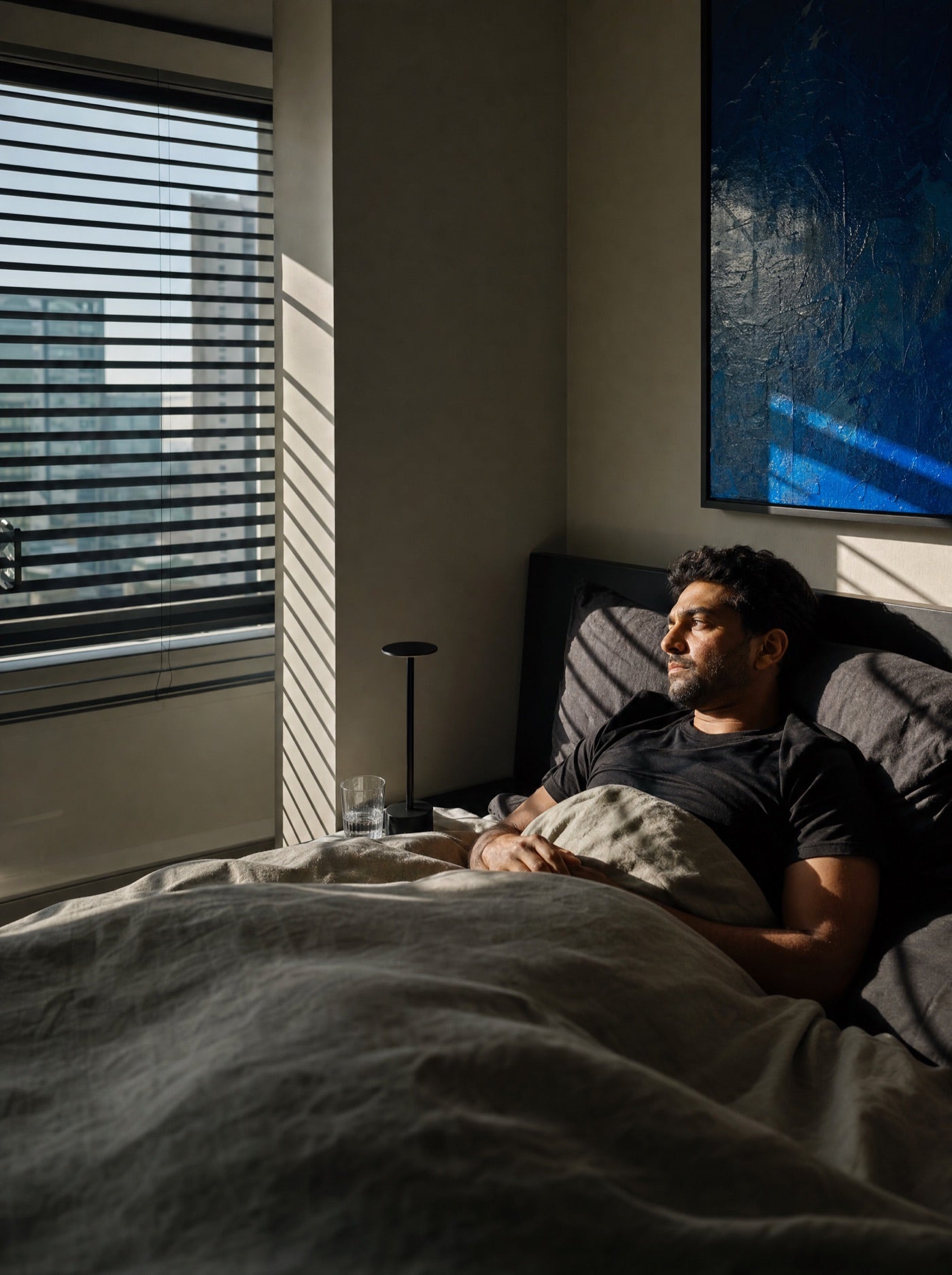 Tired night-shift worker trying to rest in a bright daytime bedroom
