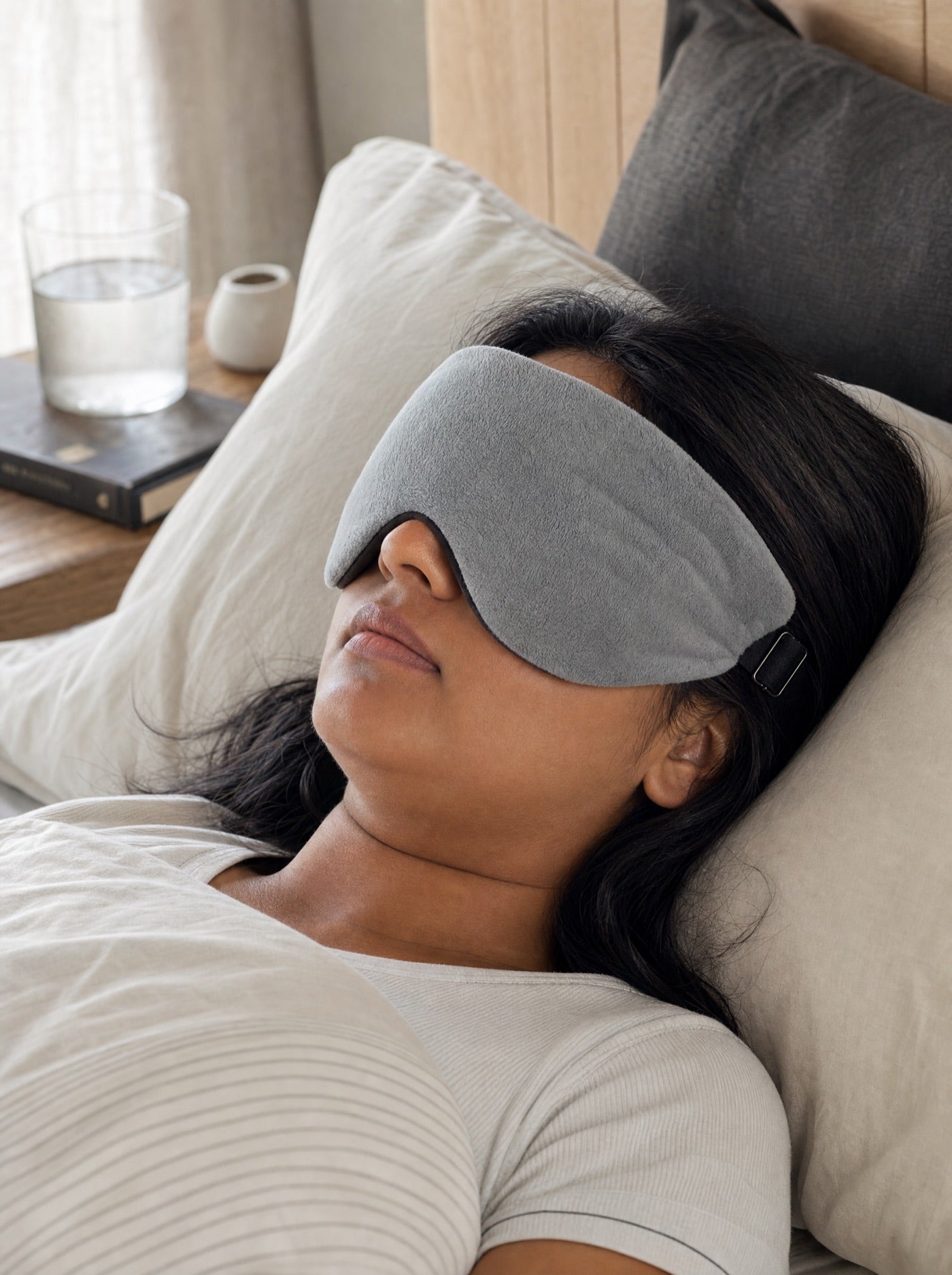 Person resting in daylight while wearing the grey weighted sleep mask